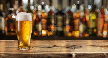 Foto de Glass of chilled beer on table and blurred sparkling bar background. - Imagen libre de derechos