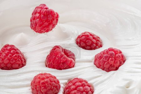 Foto de Frambuesas frescas en yogur o crema. Vista superior. - Imagen libre de derechos