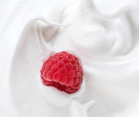 Foto de Frambuesa fresca en yogur o crema. Primer plano. - Imagen libre de derechos