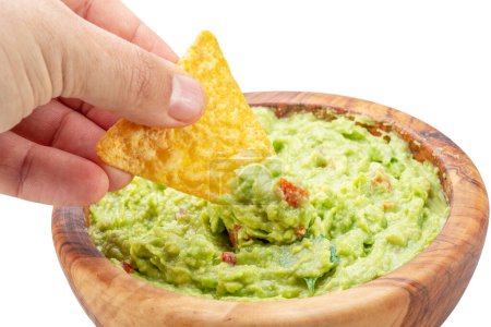 Photo for Dipping corn chips into guacamole on white background. - Royalty Free Image