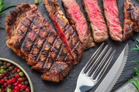 Téléchargez les photos : Délicieux steak de côtelette grillé tranches ardoise noire plat de service. Pose plate. - en image libre de droit