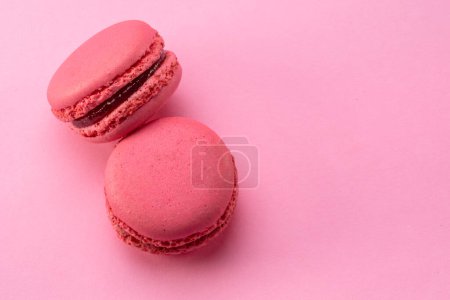 Téléchargez les photos : Two pink french macarons isolated on pink background. - en image libre de droit