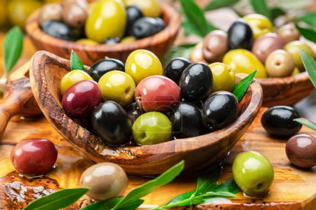 Photo for Kalamata, green and black olives in the wooden plate. Food background. - Royalty Free Image