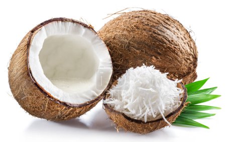 Coconut milk in cracked coconut fruit and coconut shreds on white background.