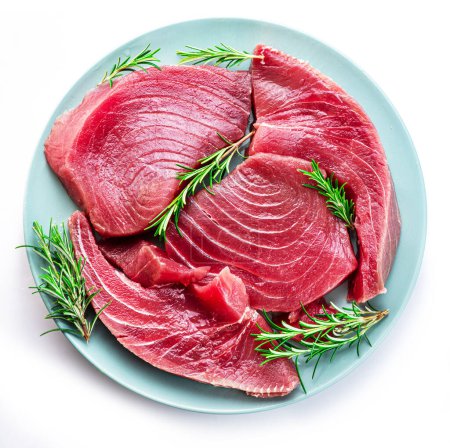 Foto de Fresh tuna steaks on blue plate isolated on white background. - Imagen libre de derechos