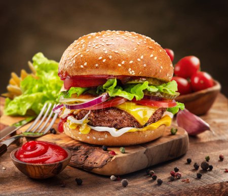 Foto de Sabrosa hamburguesa con queso o hamburguesa en bandeja de madera, especias y verduras cerca de ella. - Imagen libre de derechos