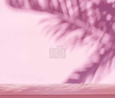 Photo for Blurred shadow of tropical palm leaves on pink wall and table top in the foreground. Summer concept. - Royalty Free Image