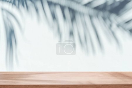 Photo for Blurred shadow of tropical palm leaves on gray wall and table top in the foreground. Summer concept. - Royalty Free Image