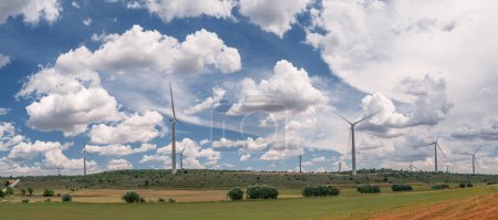Photo for Wind turbines in rural landscape and stunning cloudy sky at the background. Environmentally friendly production of electrical energy. - Royalty Free Image