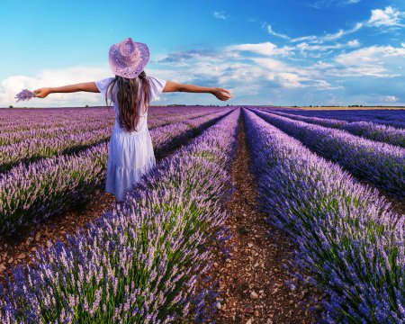Photo for Young girl in the lavender field and cloudy sky at the background. Brihuega, Spain. - Royalty Free Image
