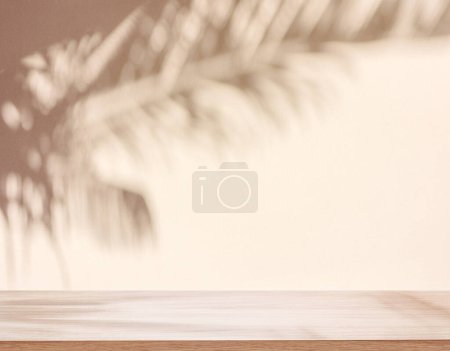 Téléchargez les photos : Ombre floue de feuilles de palmier tropicales sur un mur beige et dessus de table au premier plan. Concept d'été. - en image libre de droit