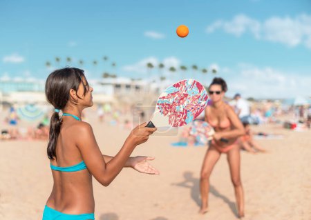 Téléchargez les photos : Maman et fille jouant au tennis de plage ou au padel tennis à la plage. - en image libre de droit