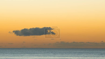 Téléchargez les photos : Partie colorée du ciel après la disparition du soleil au-dessus de la mer calme. - en image libre de droit