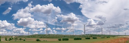 Photo for Wind turbines in rural landscape and stunning cloudy sky at the background. Environmentally friendly production of electrical energy. - Royalty Free Image
