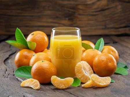 Foto de Frutas de mandarina de naranja y vaso de jugo de mandarina fresca sobre fondo de madera oscura. Vista superior. - Imagen libre de derechos