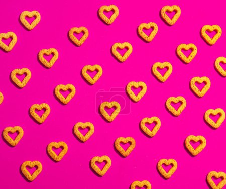 Photo for Small yellow heart-shaped cookies on a pink background. A beautiful background for Valentine's Day. - Royalty Free Image
