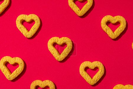 Photo for Small heart-shaped cookies on a red background. A beautiful background for Valentine's Day. - Royalty Free Image