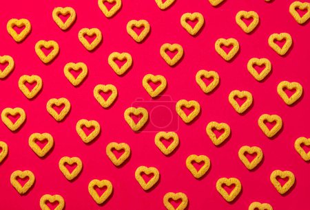 Small heart-shaped cookies on a red background. A beautiful background for Valentine's Day.