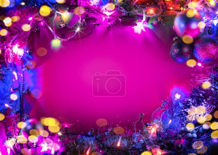 Foto de Decoración del árbol de Navidad con luces de hadas dispuestas como marco de borde sobre fondo rosa. - Imagen libre de derechos