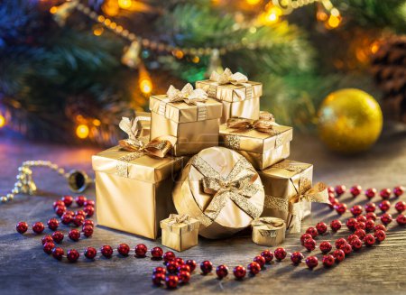 Téléchargez les photos : Cadeaux de Noël comme symbole du bonheur et du miracle de Noël. Fées scintillantes lumières sur le sapin de Noël à l'arrière-plan. - en image libre de droit