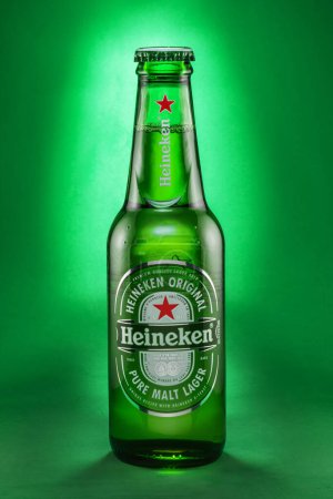 Foto de Portugal, Lisboa, 9 de diciembre de 2023: Botella de cerveza Heineken lager 0.33l aislada sobre un fondo verde. Heineken es una marca de cerveza holandesa, una de las más populares del mundo.. - Imagen libre de derechos