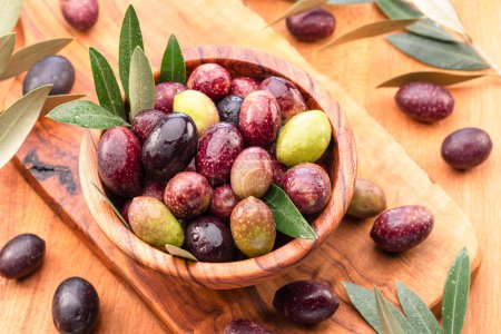 Photo for Fresh olives in wooden bowl on the wood background. - Royalty Free Image