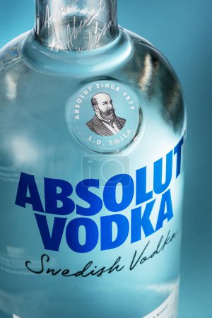Téléchargez les photos : Portugal, Lisbonne, 21 décembre 2023 : Bouteille de vodka suédoise Absolut sur fond bleu. Vodka Absolut - l'une des marques de vodka les plus populaires au monde, produite depuis 1879 dans le sud de la Suède. - en image libre de droit