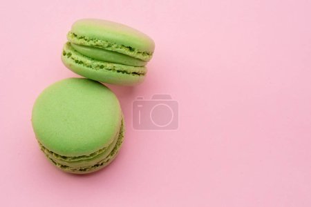 Foto de Dos macarrones franceses verdes aislados sobre fondo rosa. - Imagen libre de derechos