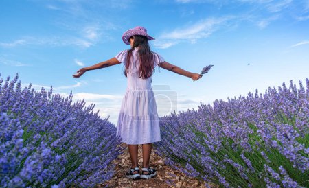 Téléchargez les photos : Jeune fille dans le champ de lavande et ciel nuageux à l'arrière-plan. Brihuega, Espagne. - en image libre de droit
