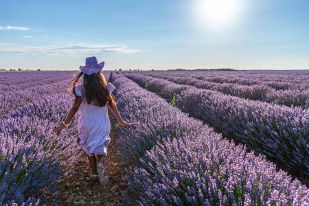 Junges Mädchen läuft zwischen Lavendelbüschen auf dem Feld. Brihuega, Spanien.