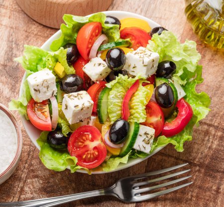 Photo for Greek salad on  wooden table served and ready to eat. - Royalty Free Image
