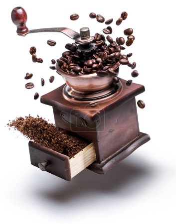 Foto de Imagen conceptual de molinillo de café manual o molino de café y granos de café levitando en el aire a su alrededor. - Imagen libre de derechos