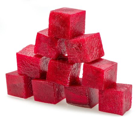 Cubos de remolacha roja cruda dispuestos como pirámide aislada sobre fondo blanco. 