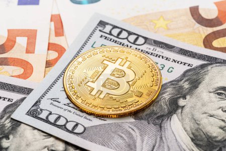 Téléchargez les photos : Bitcoin d'or pièce sur fond de monnaies traditionnelles, billets en papier de dollars et d'euros. - en image libre de droit