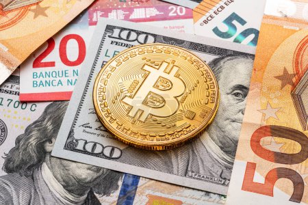 Foto de Bitcoin de oro en el contexto de las monedas tradicionales, billetes de papel de dólares y euros. - Imagen libre de derechos