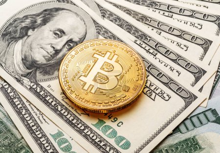 Foto de Bitcoin de oro en el contexto de las monedas tradicionales billetes de papel de dólares. - Imagen libre de derechos