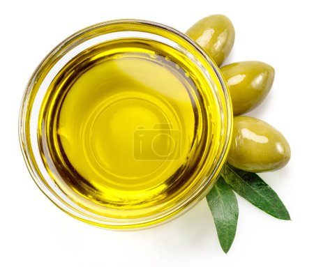 Cuenco de vidrio de aceite de oliva y bayas de oliva aisladas sobre fondo blanco. Vista superior.