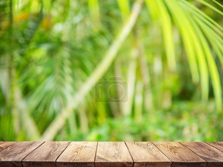 Téléchargez les photos : Empty wooden board or table top and blurred green bamboo culms. Place for your product display. - en image libre de droit