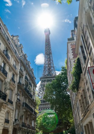 Téléchargez les photos : Tour Eiffel, le monument le plus visité de France. Vue du bas de près à travers vert été luxuriant. - en image libre de droit