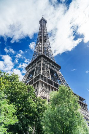 Téléchargez les photos : Eiffel Tower, the most visited landmark in France. Bottom view close up through green summer lush. - en image libre de droit