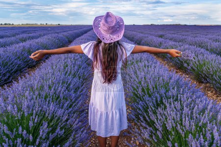 Photo for Young girl in the lavender field and cloudy sky at the background. Brihuega, Spain. - Royalty Free Image