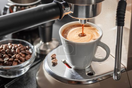 Cafetera automática. Verter café en el primer plano de la taza de café. 