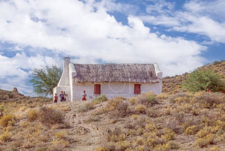 Foto de PASO ROBINSON, SUDÁFRICA - 22 DE ABRIL DE 2023: Niños fuera de una casa de paja tradicional cerca del pie del paso Robinson en las montañas Outeniqua de la Provincia Occidental del Cabo de Sudáfrica. - Imagen libre de derechos