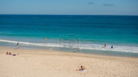 Foto de PERTH, AUSTRALIA - 26 de agosto de 2023: Personas no identificadas se relajan en Floreat Beach en Perth, Australia Occidental. Rottnest Island se puede ver en el horizonte. - Imagen libre de derechos
