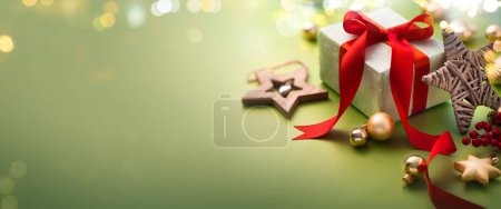 Foto de Tarjeta de felicitación de Navidad o diseño de banner de Navidad - Caja de regalo y adornos sobre fondo verde claro con luces mágicas - Imagen libre de derechos