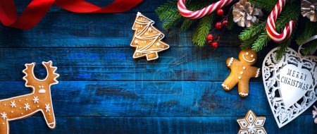 Foto de Regalos dulces de Navidad, bastón de caramelo y hombre de jengibre - rama de abeto - Banner de Navidad, encabezado, con espacio para copiar - Imagen libre de derechos