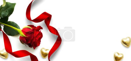 Foto de Banner Design elements for Valentine's Day background. Red rose flower, Heart shaped golden candies and Red ribbon on a white background, flat lay - Imagen libre de derechos