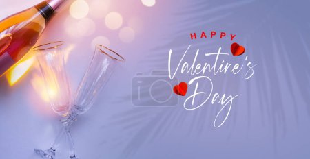 Foto de Greeting banner or card happy valentine's day. Champagne wine and two glasses of wine on a romantic tropical pink background - Imagen libre de derechos