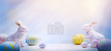 Foto de Design for Easter banner background with copy space; Easter bunny family and Easter eggs on wooden background - Imagen libre de derechos