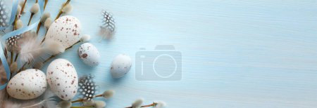 Téléchargez les photos : Composition de Pâques avec oeufs de Pâques et fleurs de printemps sur fond de table bleu - en image libre de droit